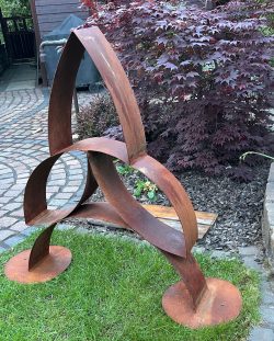 Abstrakte, dreidimensionale Skulptur aus drei ineinander verschlungenen, bogenförmigen Bändern aus Stahl mit Rost-Patina.