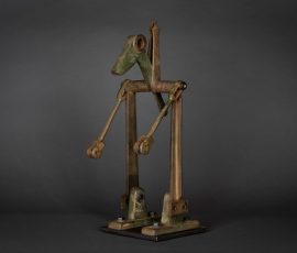 Filigrane, anthropomorphe Gelenkskulptur aus patinierten Metallelementen mit angedeuteter Tierkopf-Silhouette.